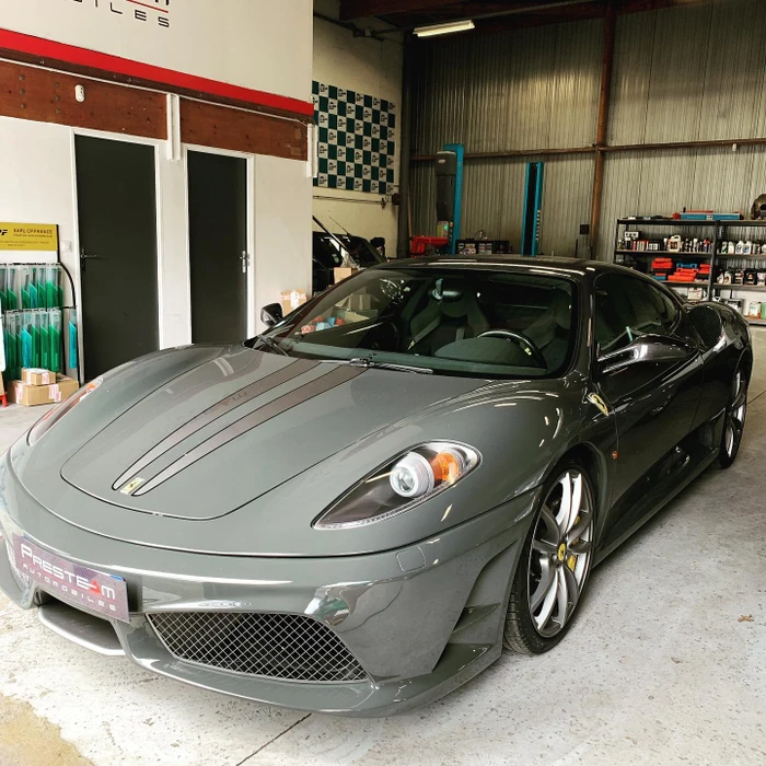 Garage automobile professionnel, Ferrari F430 grise métallisée stationnée à l'intérieur