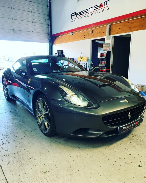 Garage automobile intérieur, Ferrari California gris anthracite métallisé stationnée face caméra